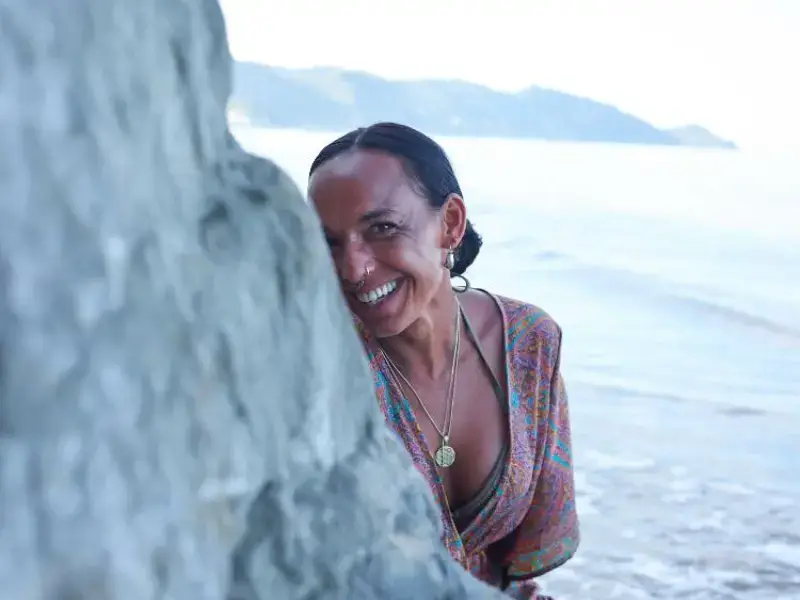 dunja am strand hinter einem felsen sitzend